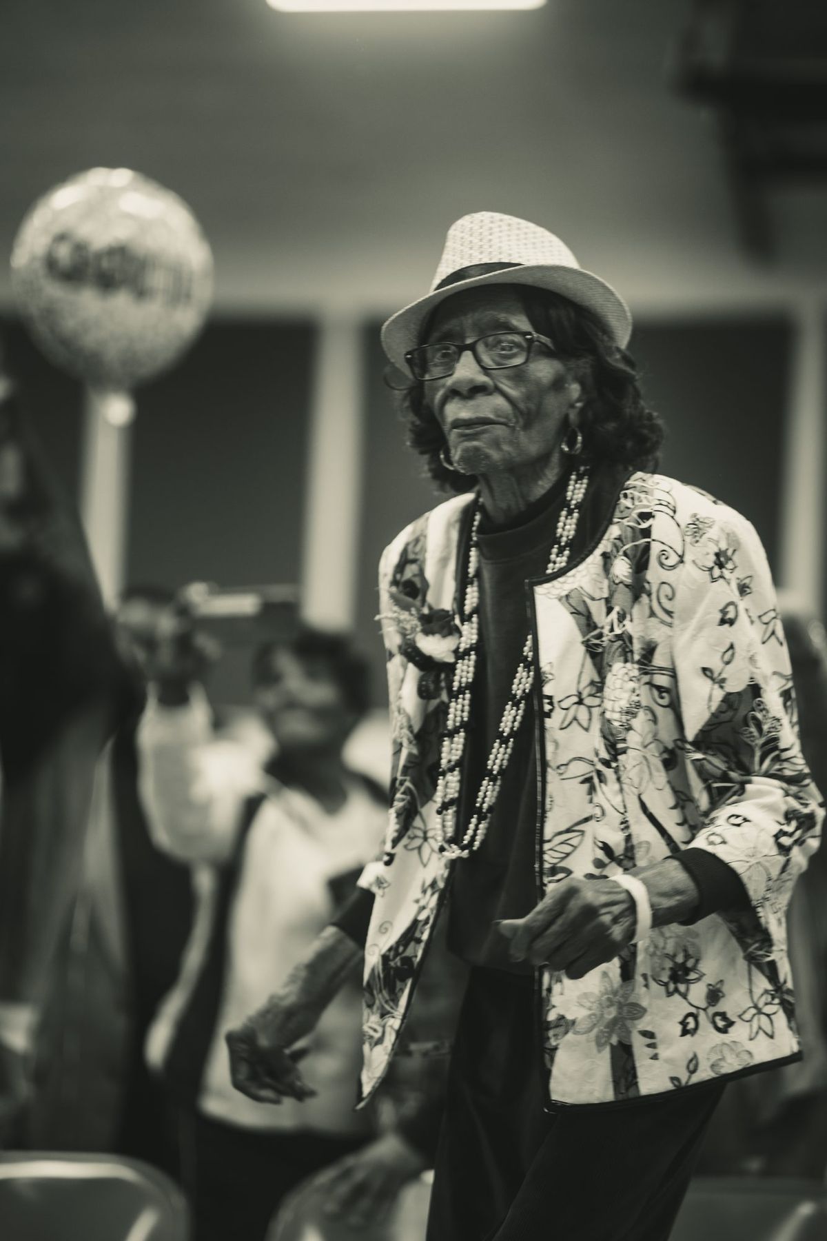 An elder in a straw hat walking the floor